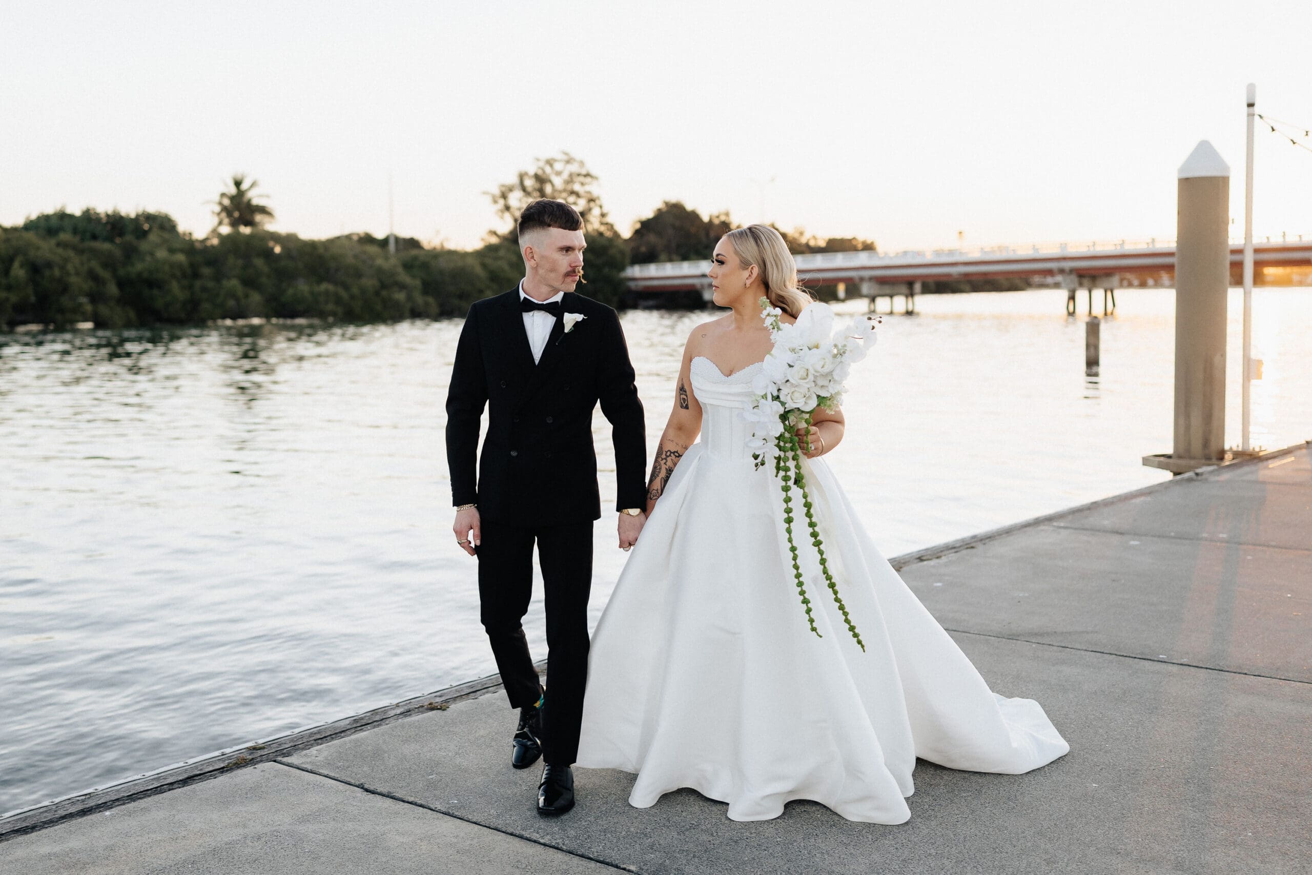 lla and Lachie walking by the water on their wedding day