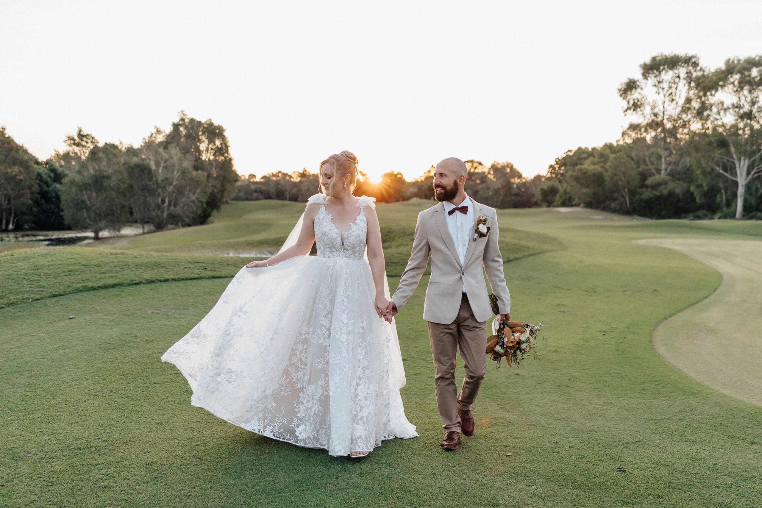 Rachel and Kieren walking together at sunset during their wedding at The Tides, Bribie Island